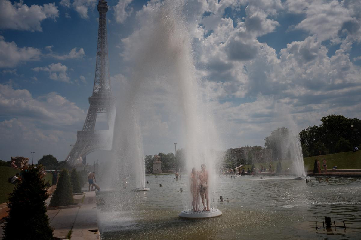  Casal se refresca na Fonte do Trocadéro, próximo a Torre Eiffel/ AFP