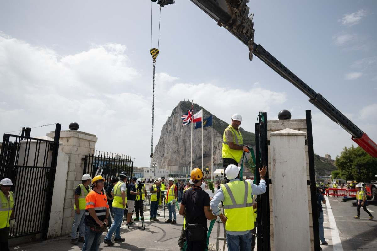 Trabalhadores desmontam a cerca fronteiriça entre a Espanha e o território britânico ultramarino de Gibraltar, no posto de fronteira de La Línea de la Concepción, no sul da Espanha ( AFP)