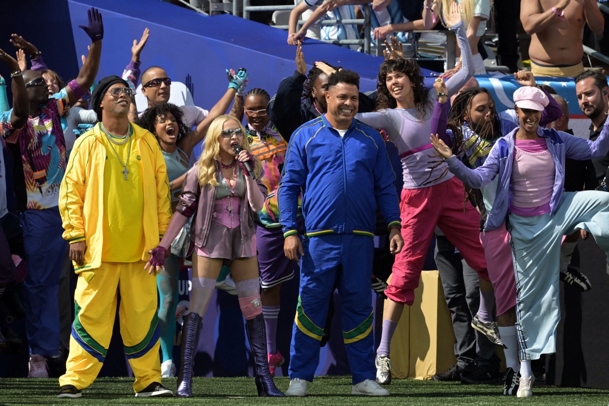 A cantora americana Madonna (ao centro) se apresenta com o jogador de futebol brasileiro Ronaldinho (à esquerda) e o ex-jogador brasileiro Ronaldo durante o show do intervalo da final da Copa do Mundo de 2026/ AFP