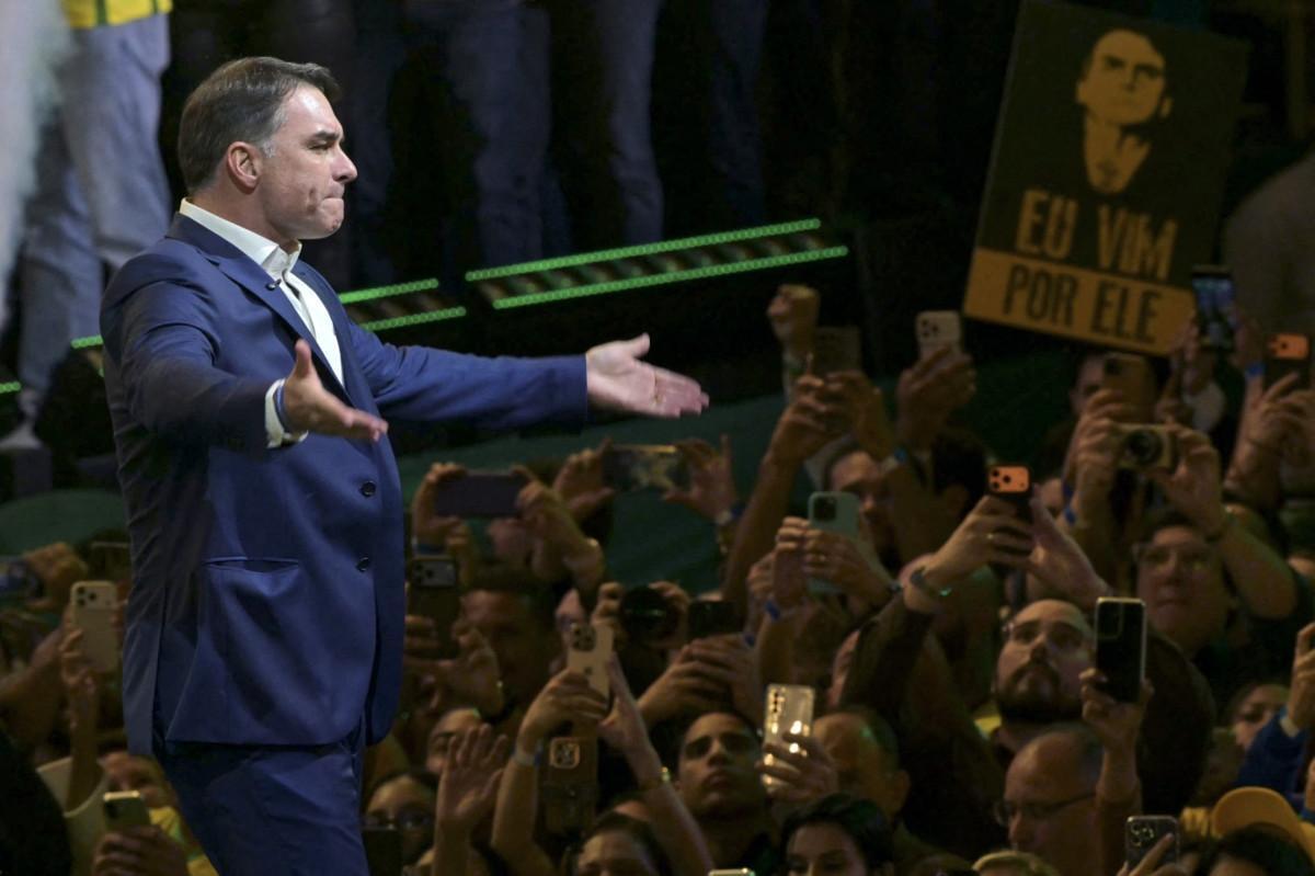 Flavio Bolsonaro faz gestos ao chegar à convenção do Partido Liberal (PL)/Nelson Almeida/AFP