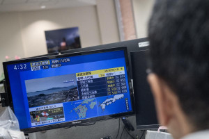 Rep&oacute;rteres acompanham o notici&aacute;rio que mostra um grande terremoto e uma poss&iacute;vel onda de tsunami de um metro no sul do Jap&atilde;o, a partir de um escrit&oacute;rio em T&oacute;quio, em 28 de julho de 2026