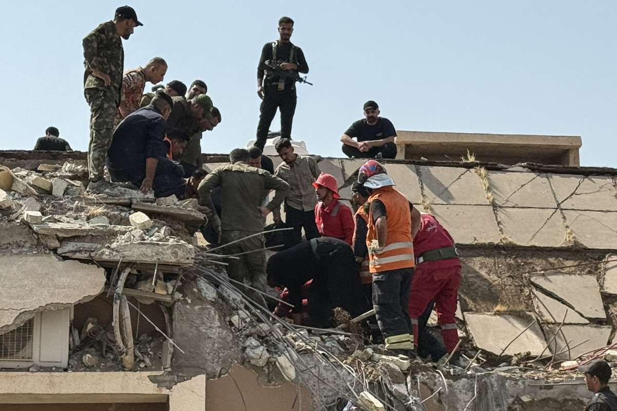 Forças de segurança e equipes de emergência trabalham no local de ataques realizados pelos EUA e pela Arábia Saudita/YOUNIS AL-BAYATI / AFP