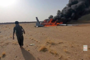 Rebeldes houthis junto aos destro&ccedil;os de um drone saudita abatido, no noroeste do I&ecirc;men.