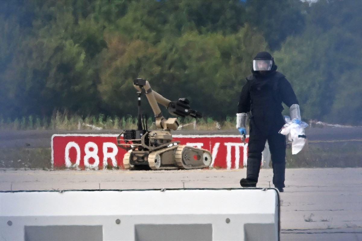 Técnico forense trabalha ao lado de robô antibombas no Aeroporto de Leipzig/Halle,  no leste da Alemanha/Hendrik Schmidt/AFP