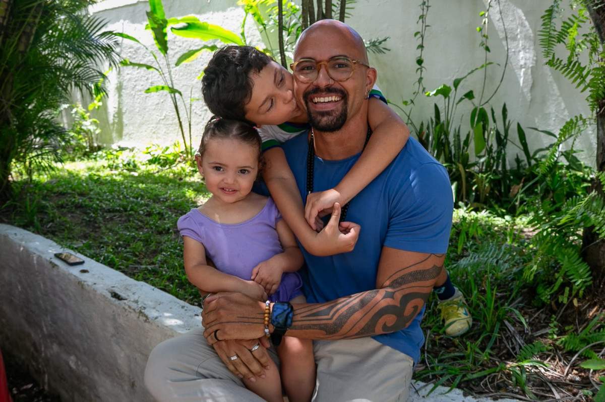 Professor de artes e música Íkaro Lima Cavalcante, 37 anos, e seus dois filhos (Foto: Rafael Vieira/DP)