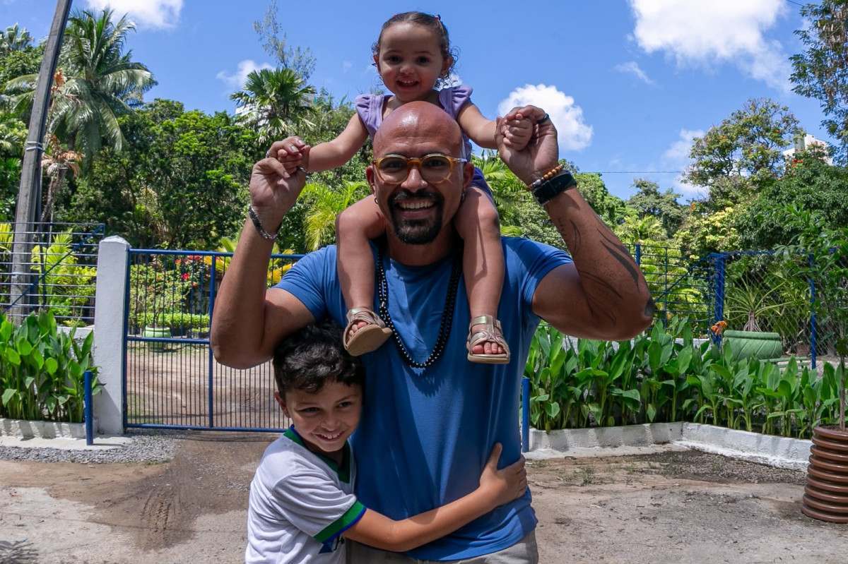 Professor de artes e música Íkaro Lima Cavalcante, 37 anos, e seus dois filhos (Foto: Rafael Vieira/DP)