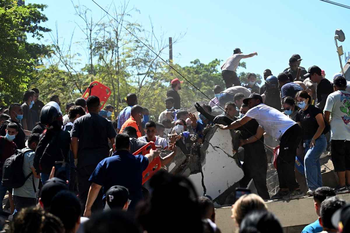 Pessoas buscam sobreviventes em meio aos escombros de um prédio que desabou após um terremoto em Cali, na Colômbia/Joaquin SARMIENTO / AFP