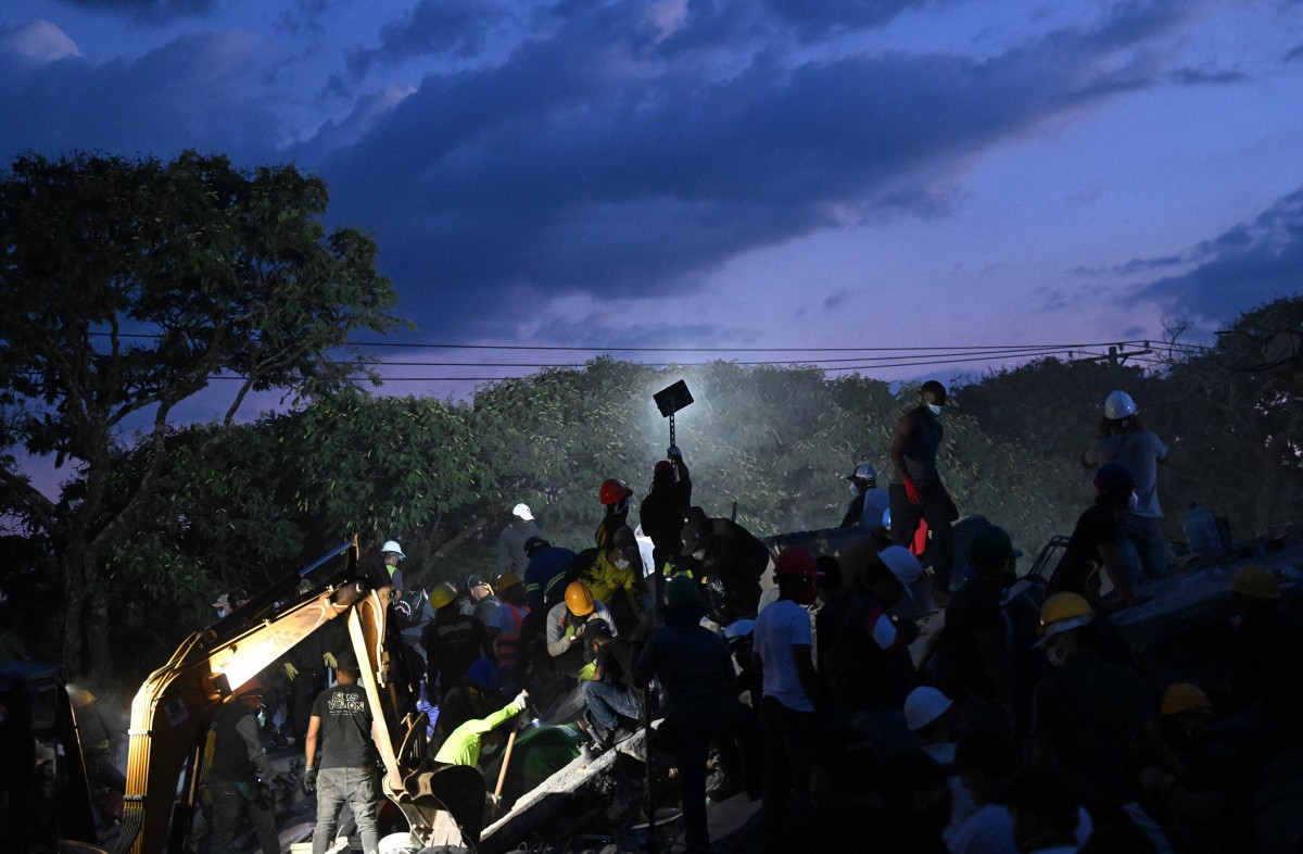 Voluntários e equipes de resgate colombianos removem escombros até mesmo com as próprias mãos em busca de sobreviventes/ JOAQUIN SARMIENTO / AFP