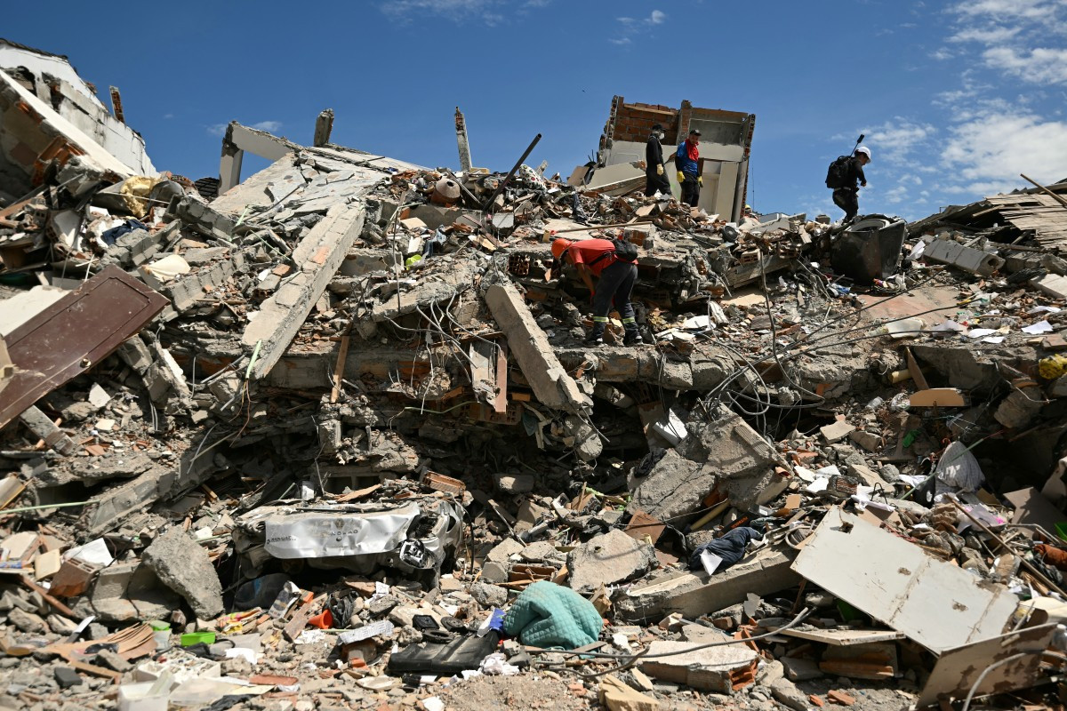 Equipes de resgate e outras pessoas buscam sobreviventes entre os escombros de um prédio que desabou, três dias após um terremoto de magnitude 7,4 em Pereira, na Colômbia/LUIS ACOSTA/AFP