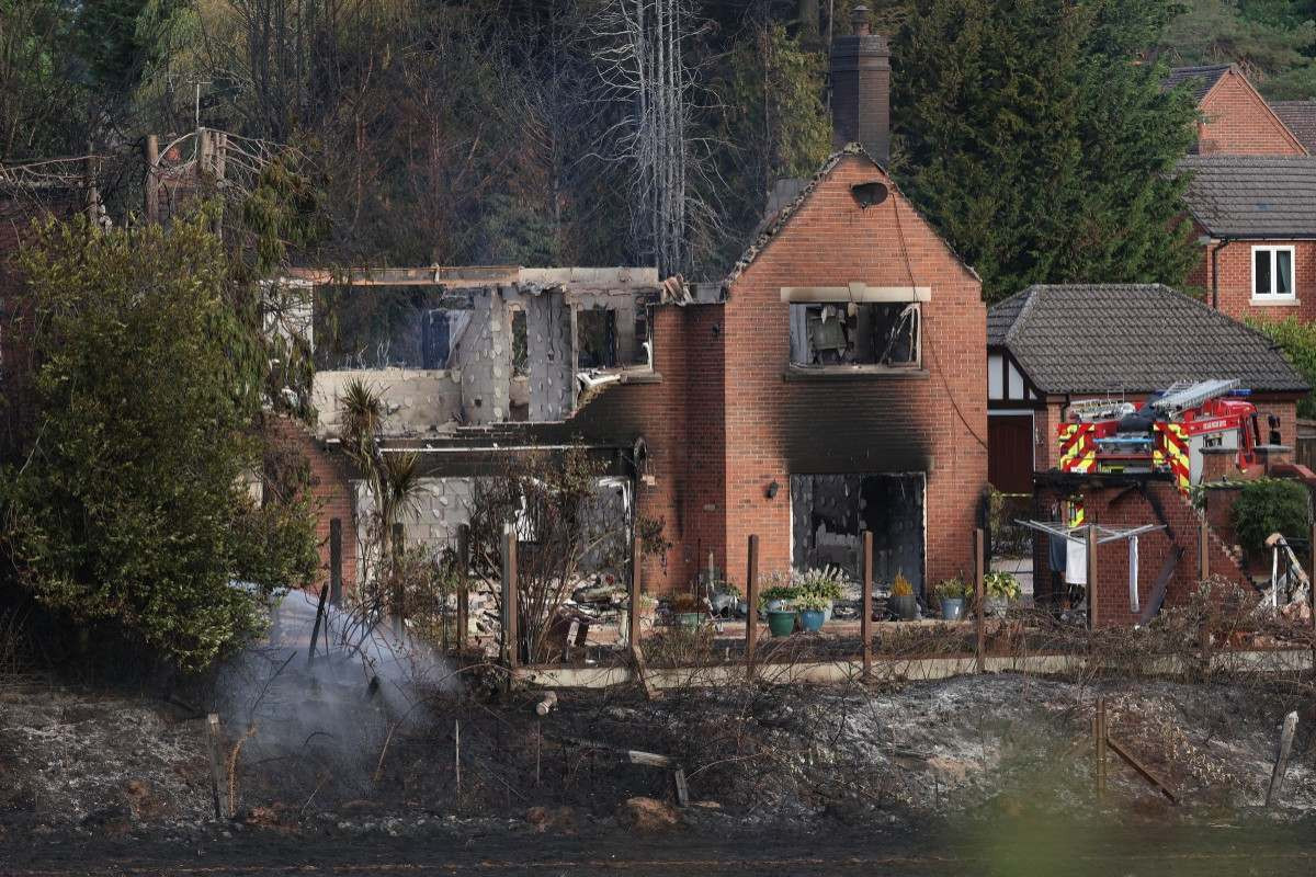 Bombeiros trabalham no local de uma casa danificada pelo fogo em Stourbridge, no centro da Inglaterra/ Darren Staples / AFP