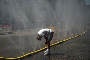 Em meio a ondas de calor, homem refresca a cabe&ccedil;a em jatos de &aacute;gua em Col&ocirc;nia, no oeste da Alemanha