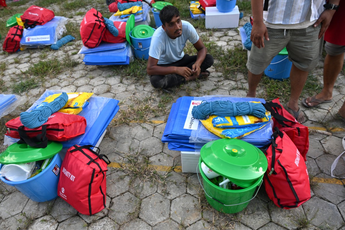  Moradores se reúnem para receber ajuda com serviços básicos em um hospital transformado em abrigo temporário após tragédia no Nepal/Arun Sankar/AFP