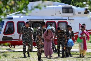 Equipes de resgate socorrendo uma mulher v&iacute;tima das inunda&ccedil;&otilde;es que aconteceu entre o Nepal e Tibete