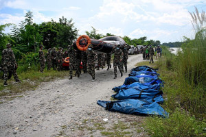 Militares do ex&eacute;rcito do Nepal retornam de uma opera&ccedil;&atilde;o de busca com os corpos de v&iacute;timas fatais de enchentes em Bharatpur, no distrito de Chitwan, no Nepal
