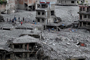 Pessoas buscam materiais aproveit&aacute;veis ??entre os escombros ap&oacute;s enchentes repentinas no Centro Trishuli, no distrito de Nuwakot, no Nepal