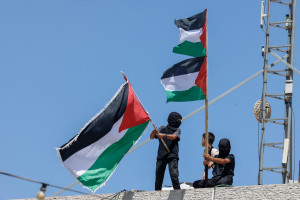 Meninos acenam bandeiras palestinas durante funeral dos jovens Khalil Rasem, de 16 anos, e Omar Mohammad Naji al-Nassan, de 19
