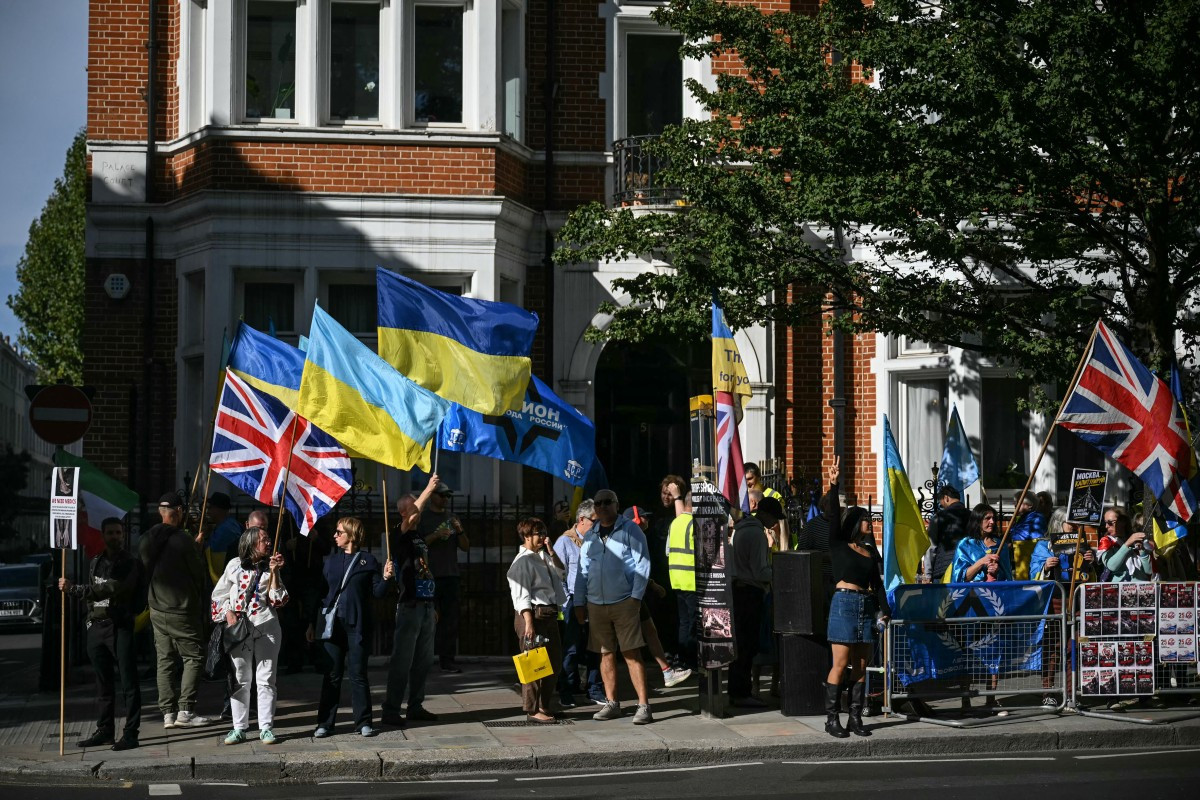 Manifestantes pró-Ucrânia se reúnem na entrada da rua que leva à embaixada russa no centro de Londres, local de votação / AFP