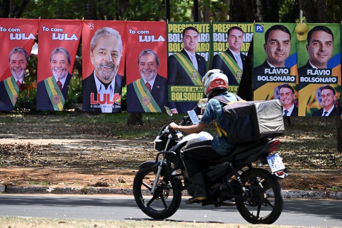  Flags and towels bearing the images of Brazil's President and presidential candidate Luiz Inacio Lula da Silva and right-wing senator and presidential candidate Flavio Bolsonaro are displayed for sale on a street in Brasilia on September 30, 2026. Brazil will hold presidential election on October 4, 2026. (Photo by Evaristo Sa / AFP)
      Caption/EVARISTO SA/AFP
