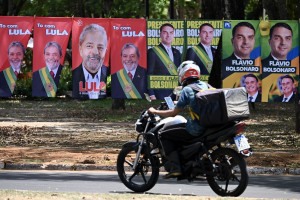  Flags and towels bearing the images of Brazil's President and presidential candidate Luiz Inacio Lula da Silva and right-wing senator and presidential candidate Flavio Bolsonaro are displayed for sale on a street in Brasilia on September 30, 2026. Brazil will hold presidential election on October 4, 2026. (Photo by Evaristo Sa / AFP)
      Caption