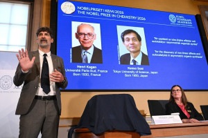Ganhadores do Pr&ecirc;mio Nobel Henri Kagan, da Fran&ccedil;a, e Kenso Soai, do Jap&atilde;o, exibidos em uma tela