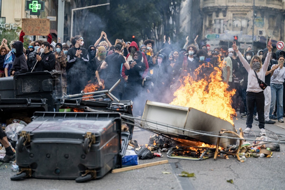 Manifestantes protestam em meio às chamas nas manifestações estudantis de Outubro na França/MIGUEL MEDINA / AFP