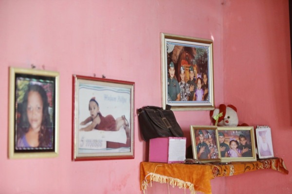 A ausência de Esther presente através imagens na parede de casa 