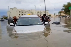 Neste vdeo da AFPTV, pessoas empurram um carro encalhado ao longo de uma inundada