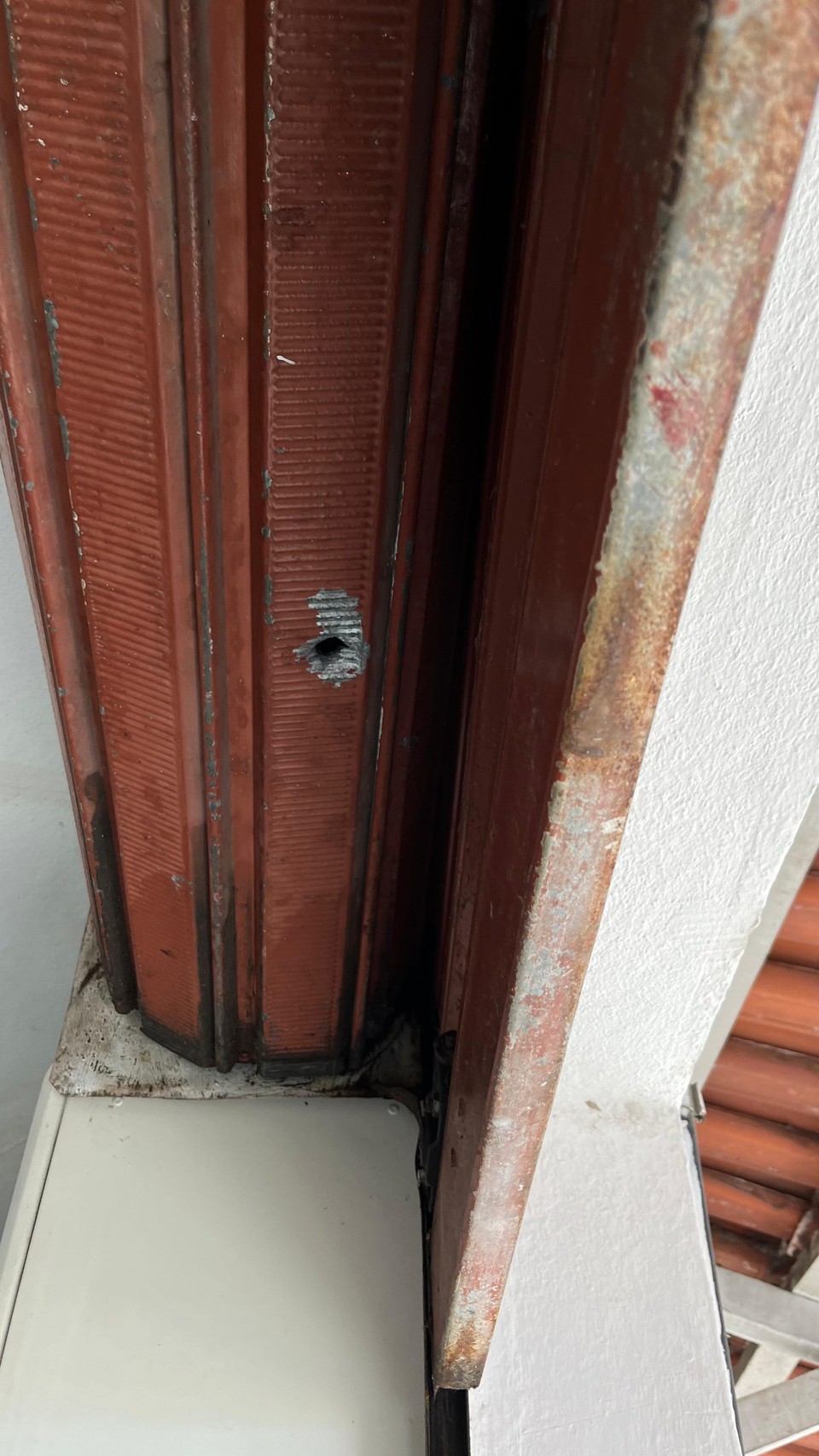 Marca de bala na porta de uma das lojas do mercado.  (Foto: Igor Fonseca/DP)