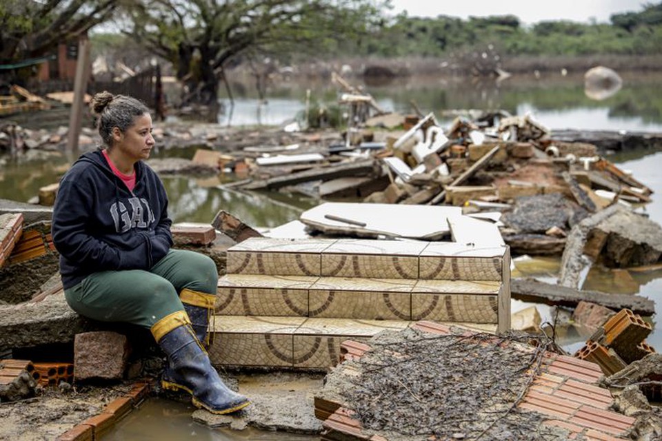 Moradora em frente ao que sobrou da sua casa  (foto: Bruno Peres/Agncia Brasil)