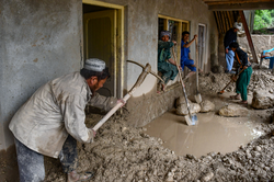 Moradores afegos removem lama de uma casa aps inundaes repentinas na aldeia de Baklak, no distrito de Dahaneh-ye Ghowri, na provncia de Baghlan