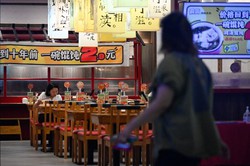 Moradores de Pequim comemoram reabertura de restaurantes (Foto: WANG Zhao / AFP)