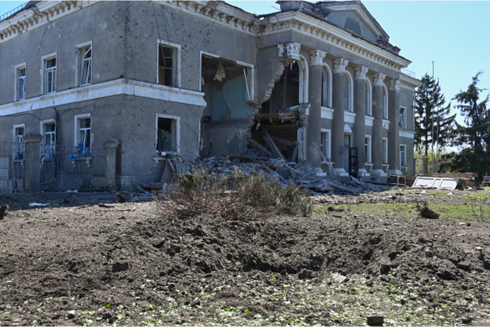 Cratera e um edifcio danificado no local de um ataque, na aldeia de Zolochiv, regio de Kharkiv (Crdito: SERGEY BOBOK / AFP)