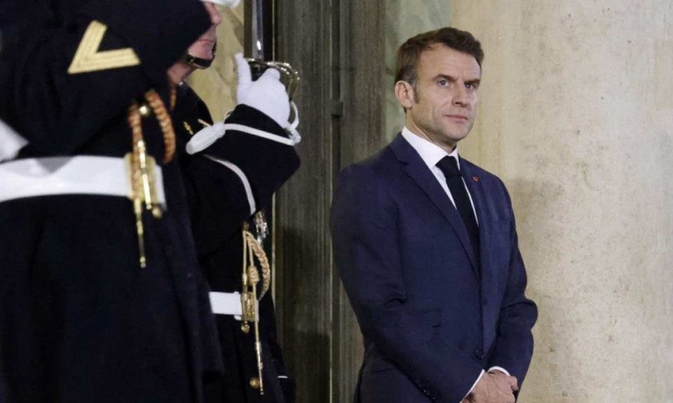 Macron, de p, protegido por policial, no Palcio Eliseu (Foto: Ludovic MARIN / AFP
)
