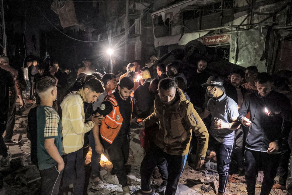 Pessoas e socorristas carregam uma vtima resgatada do local de um edifcio que foi atingido pelo bombardeio israelense em Rafah (Foto: AFP)