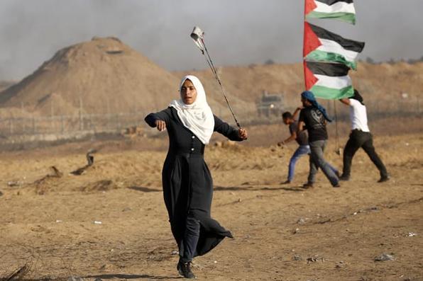 Uma mulher na Palestina usa uma tira para arremessa rocas durante os confrontos com feridas israelenses que no se manifestam em uma manifestao no largo da fronteira com Israel, que  o povo de Khan Yunis na Frana de Gaza. Foto: SAID KHATIB / AFP. - ()