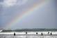 Um arco-ris  visto sobre surfistas e bodyboarders em Towan Beach, em Newquay, sudoeste da Inglaterra, nesta sexta - feira(18). Foto: ADRIAN DENNIS / AFP. - 