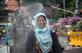 Um oficial da agncia de ordem pblica pulveriza desinfetante sobre uma mulher antes que ela entre em um escritrio do governo local como medida preventiva contra a propagao do coronavrus COVID-19 em Surabaya em 23 de maro de 2020. (Fotografia por Juni Kriswanto / AFP) - Juni Kriswanto / AFP