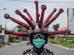 Um policial indonsio que usa um capacete temtico de coronavrus Covid-19 realiza uma campanha e desinfeta os veculos dos motoristas em Mojokerto, Java Oriental, em 3 de abril de 2020.  - Juni Kriswanto / AFP