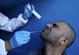 Um profissional mdico do Ministrio da Sade Palestino tira um cotonete do nariz de um homem dentro de uma ambulncia durante um teste aleatrio para a doena de coronavrus COVID-19 em pessoas que entram na cidade de Hebron na Cisjordnia ocupada em 30 de abril de 2020. - HAZEM BADER / AFP
