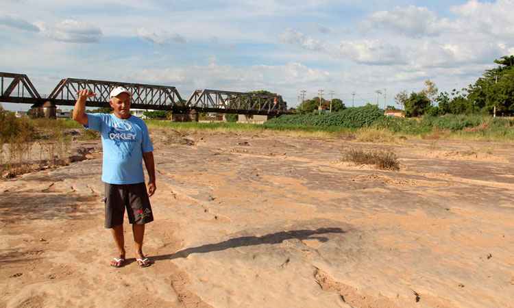 Pescador Josu Reis da Costa caminha no leito seco do rio em Pirapora e mostra que o nvel deveria estar com pelo menos 1,5 metro de profundidade. Foto: Aparcio Mansur/EM/D.A. Press
