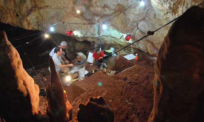 Paleontlogos trabalham na caverna em que foi encontrado o crnio de um Homo sapiens, mas com uma parte ssea caracterstica dos homindeos. Foto: Ormry Barzilai/Divulgao