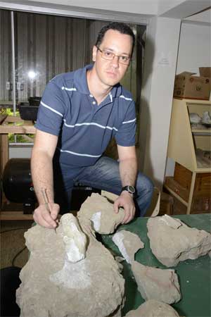 Paleontlogo Thiago Marinho examina os fsseis: parte de um fmur, com cerca de 50cm,  a maior pea. Foto: L.ADOLFO/UFMT