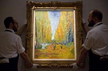 Funcionrios da Sotheby's posicionam a tela de Vincent Van Gogh "L'Alle des Aliscamps"
 AFP JUSTIN TALLIS 