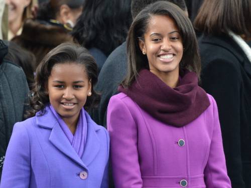 Malia est  direita, com o casaco lils da J.Crew. Foto: JEWEL SAMAD / AFP


