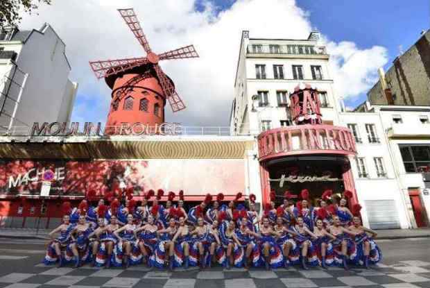 Bailarinas posam para foto em frente ao Moulin Rouge. Foto: Miguel Medina/AFP Photo