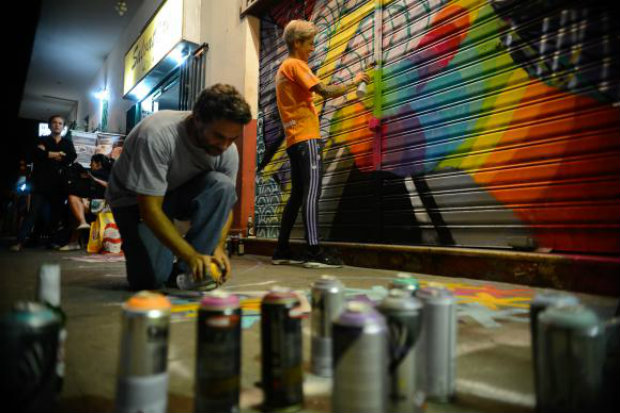 Os grafiteiros Bili Gebara e Rafaela Monteiro, a RafaMon,  pintam novamente porta da papelaria Macris, na praa So Salvador, que havia sido pichada com mensagens homofbicas. (Foto: Fernando Frazo/Agncia Brasil)