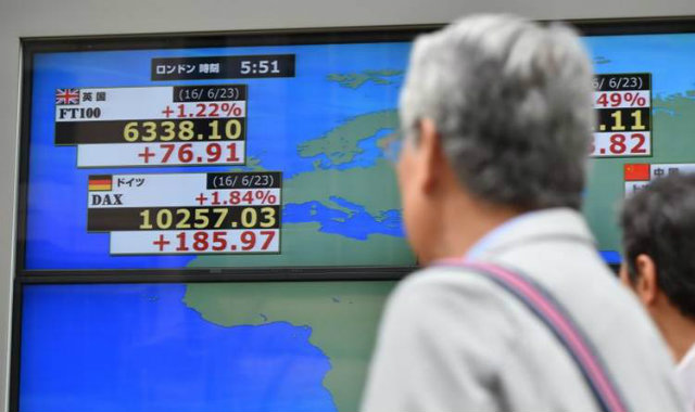Transeuntes observam indicadores financeiros em Tquio: onda de baixas causou perda de US$ 1,1 trilho apenas nas bolsas da Europa. Foto: Kazuhiro Nogi/AFP