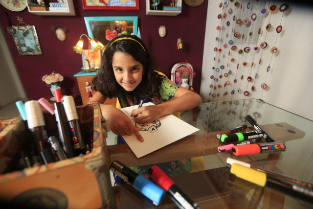 Sophia Maia lana livro com desenhos assinados por ela, criados para arrecadar fundos para os refugiados no Brasil. Foto: Rafael Martins/DP