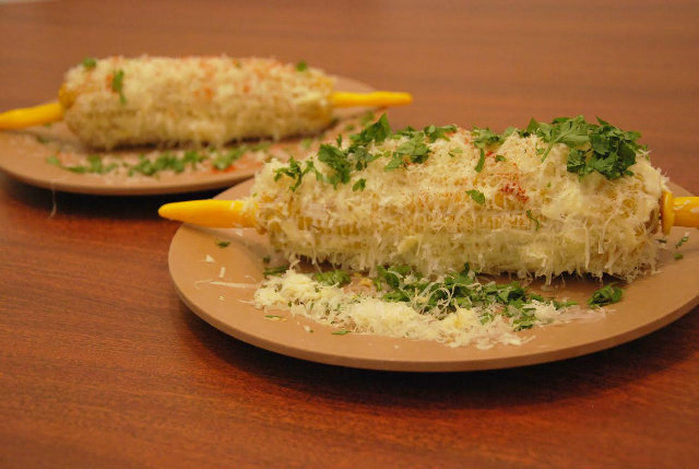 Milho Cordel (espiga cozida coberta com cream cheese, raspas de parmesão, coentro e páprica defumada), pela chef Miau Caldas. Foto: Cordel Cafés/Divulgação Milho Cordel (espiga cozida coberta com cream cheese, raspas de parmesão, coentro e páprica defumada), pela chef Miau Caldas. Foto: Cordel Cafés/Divulgação