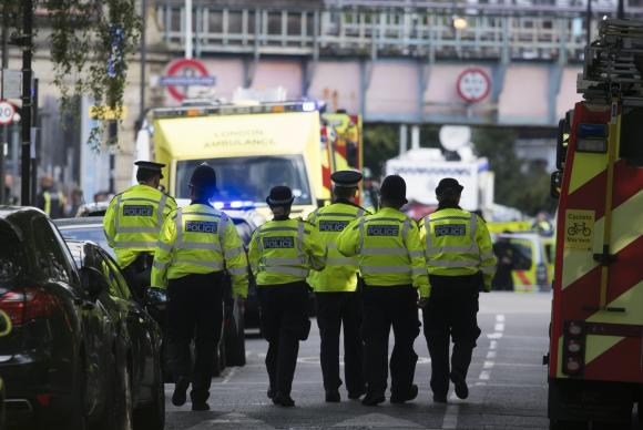 Policiais britnicos chegam  estao do metr atingida por exploso. Foto: Wiill Oliver-Agncia EFE